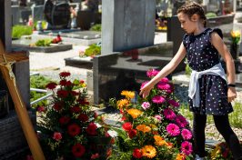 girl touching flowers at headstone of a direct cremation